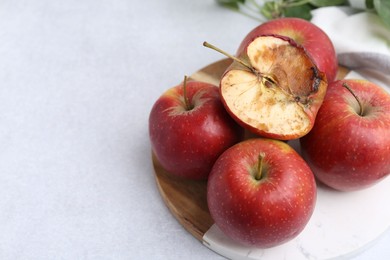 Photo of Spoiled apple and good ones on white table, closeup. Space for text