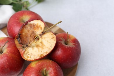 Photo of Spoiled apple and good ones on white table, closeup. Space for text
