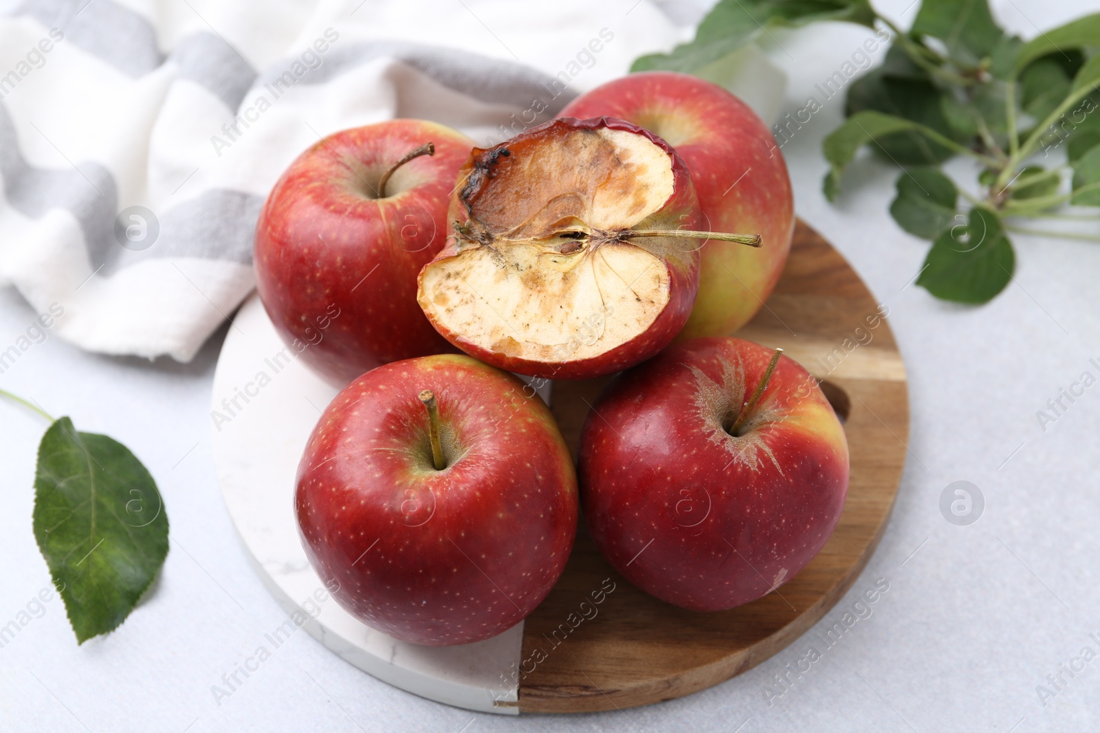 Spoiled apple and good ones on white table, closeup Photo of Spoiled apple and good ones on white table, closeup