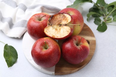 Photo of Spoiled apple and good ones on white table, closeup