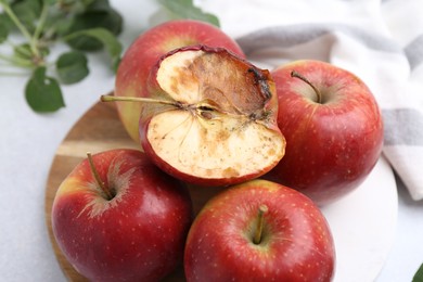 Photo of Spoiled apple and good ones on white table, closeup