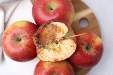 Photo of Spoiled apple and good ones on white table, top view