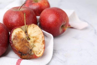 Photo of Spoiled apple and good ones on white table, closeup