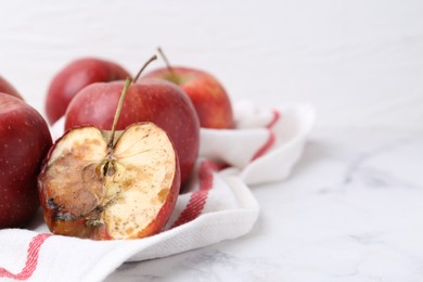 Photo of Spoiled apple and good ones on white table, closeup. Space for text