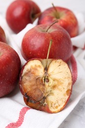 Photo of Spoiled apple and good ones on white table, closeup