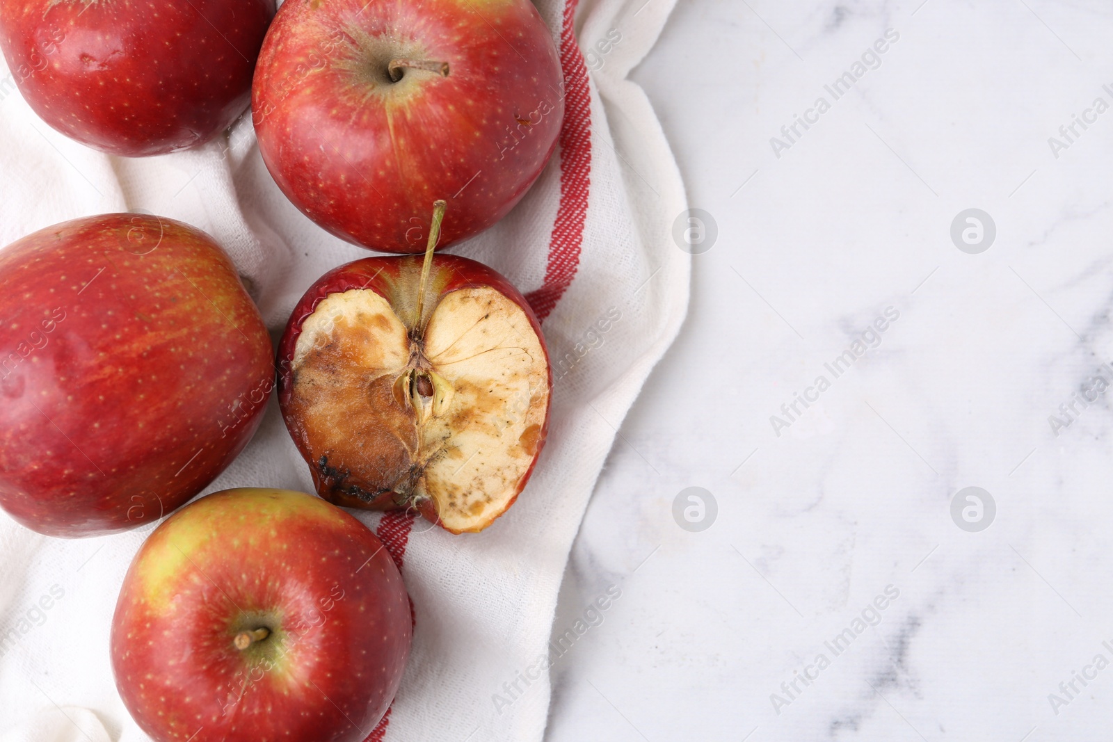 Spoiled apple and good ones on white table, flat lay. Space for text Photo of Spoiled apple and good ones on white table, flat lay. Space for text