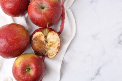 Photo of Spoiled apple and good ones on white table, flat lay. Space for text