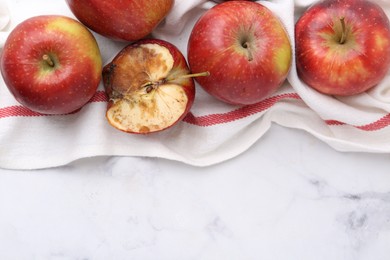 Photo of Spoiled apple and good ones on white table, flat lay. Space for text