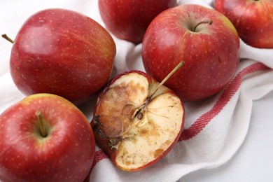 Photo of Spoiled apple and good ones on white table, closeup