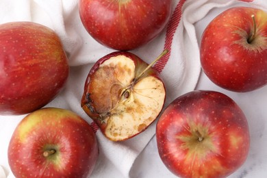 Photo of Spoiled apple and good ones on white table, flat lay