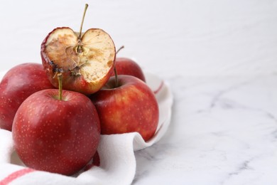 Photo of Spoiled apple and good ones on white table, closeup. Space for text
