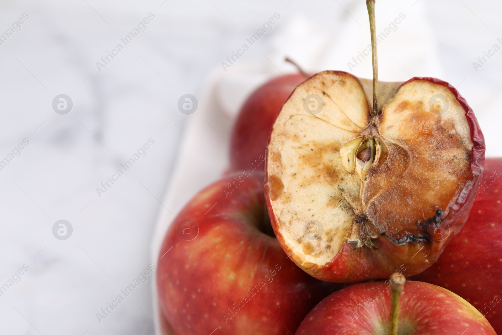 Spoiled apple and good ones on white table, closeup. Space for text Photo of Spoiled apple and good ones on white table, closeup. Space for text