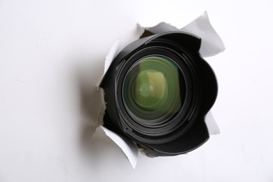 Photo of Hidden camera lens through torn hole in white paper