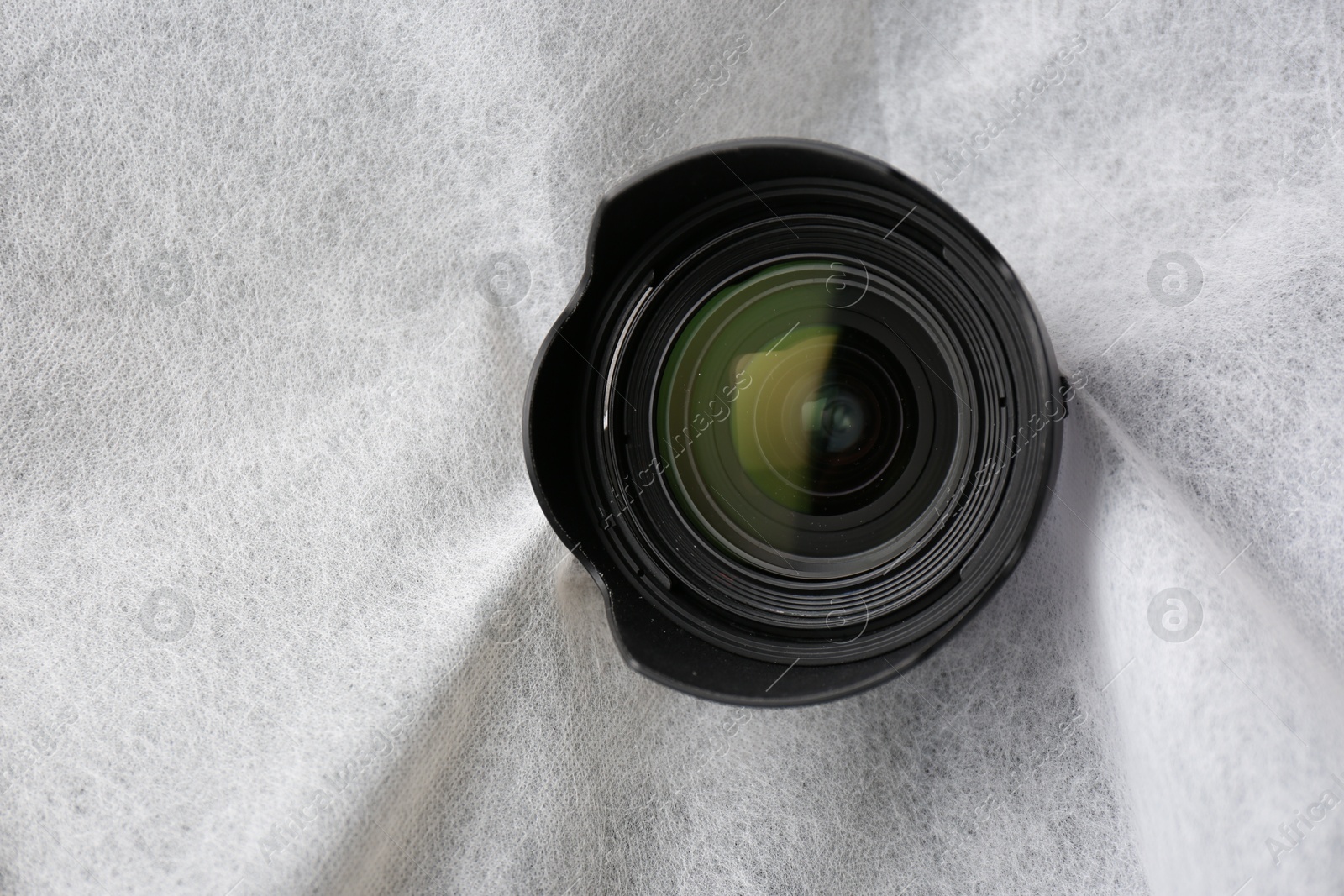 Hidden camera lens through torn hole in white fabric Photo of Hidden camera lens through torn hole in white fabric
