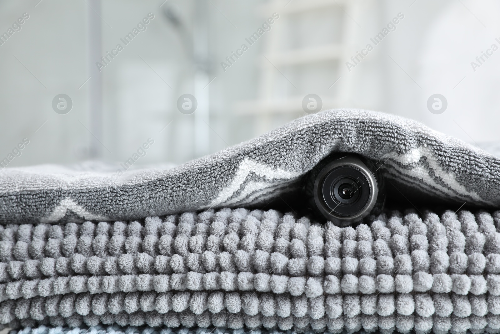Camera hidden under towel in bathroom, closeup Photo of Camera hidden under towel in bathroom, closeup
