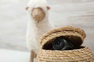 Photo of Camera hidden in wicker box, closeup. Space for text
