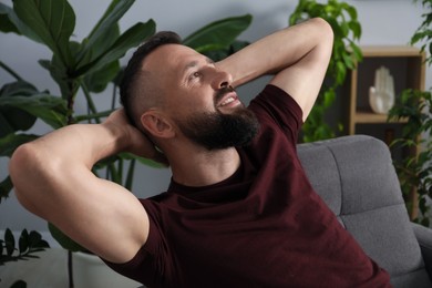 Photo of Harmony. Man relaxing in comfortable armchair at home