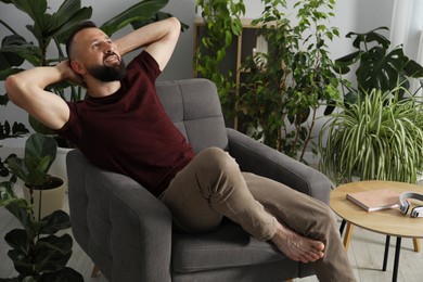 Photo of Harmony. Man relaxing in comfortable armchair at home