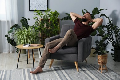 Photo of Harmony. Man relaxing in comfortable armchair at home