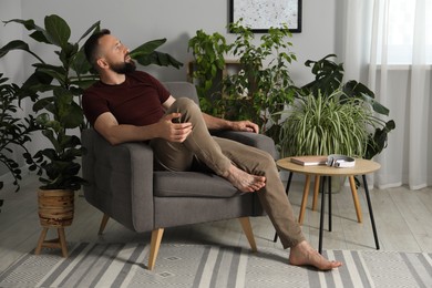 Photo of Harmony. Man relaxing in comfortable armchair at home