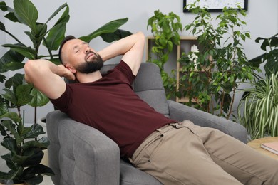 Photo of Harmony. Man relaxing in comfortable armchair at home