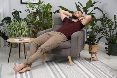 Photo of Harmony. Man relaxing in comfortable armchair at home