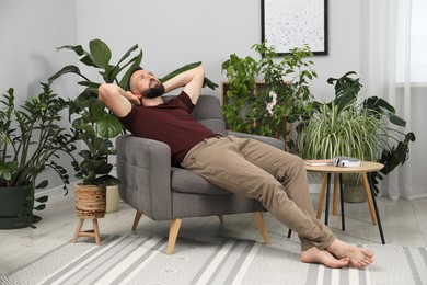 Photo of Harmony. Man relaxing in comfortable armchair at home
