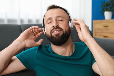 Photo of Harmony. Man listening to music in headphones at home