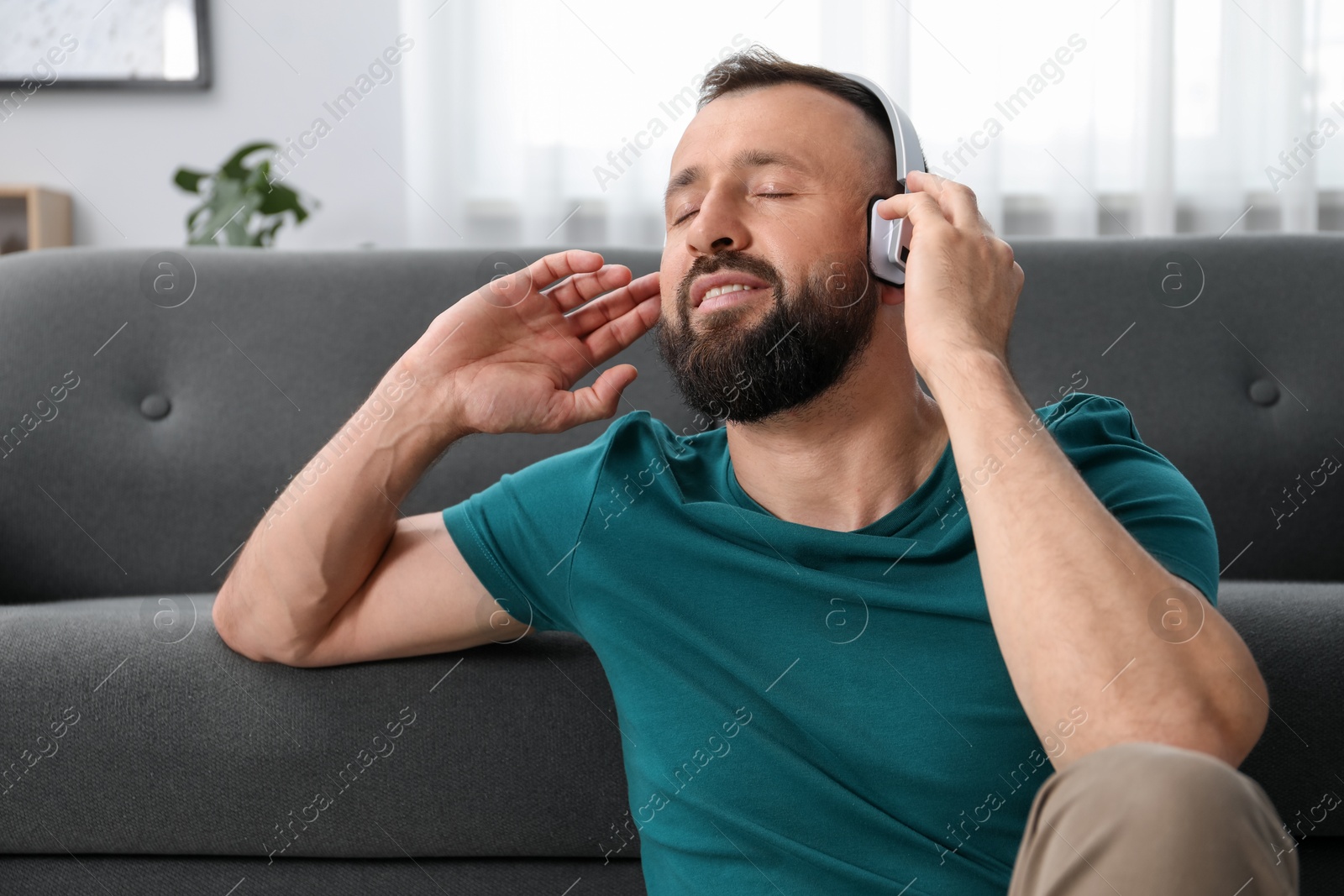 Photo of Harmony. Man listening to music in headphones at home