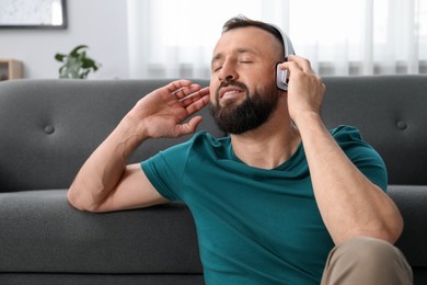 Photo of Harmony. Man listening to music in headphones at home