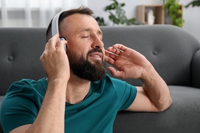 Photo of Harmony. Man listening to music in headphones at home