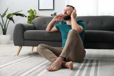 Photo of Harmony. Man listening to music in headphones at home