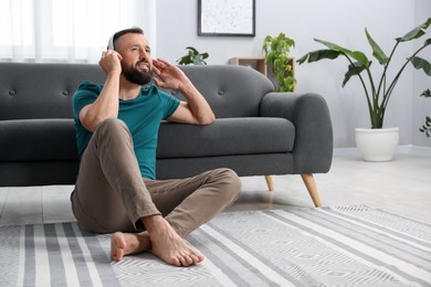 Photo of Harmony. Man listening to music in headphones at home