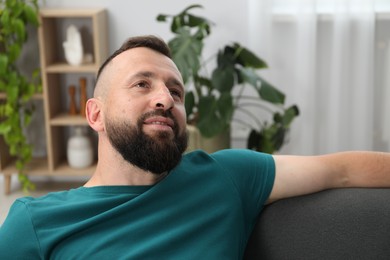 Photo of Harmony. Man relaxing on comfortable sofa at home