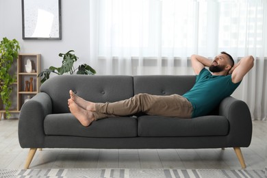 Photo of Harmony. Man relaxing on comfortable sofa at home