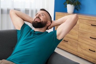 Photo of Harmony. Man relaxing on comfortable sofa at home