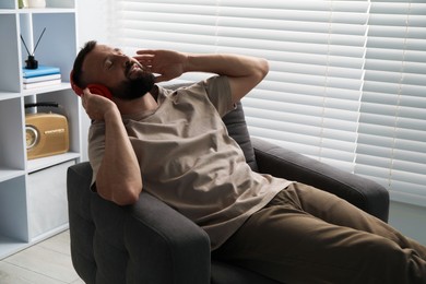 Photo of Harmony. Man listening to music in headphones at home