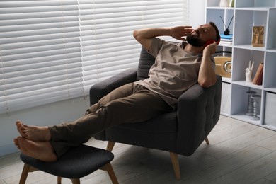 Photo of Harmony. Man listening to music in headphones at home