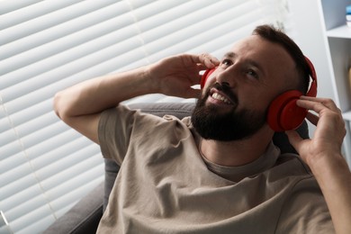 Photo of Harmony. Man listening to music in headphones at home