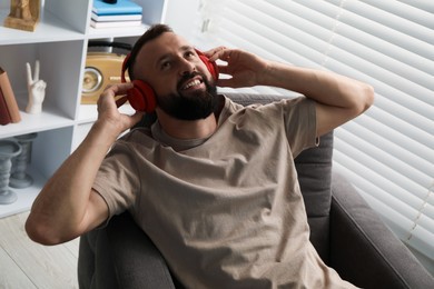 Photo of Harmony. Man listening to music in headphones at home