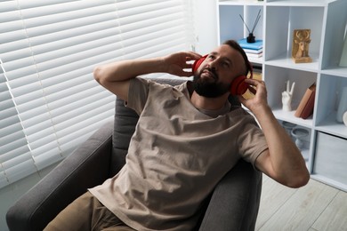 Photo of Harmony. Man listening to music in headphones at home