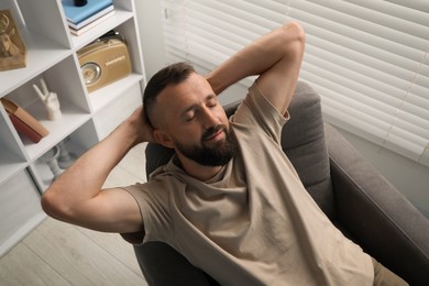 Photo of Harmony. Man relaxing in comfortable armchair at home, above view