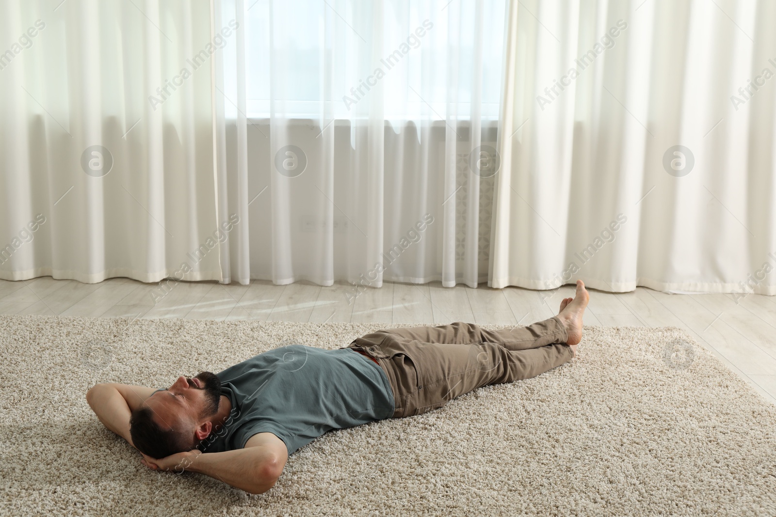 Harmony. Man lying on rug at home Photo of Harmony. Man lying on rug at home