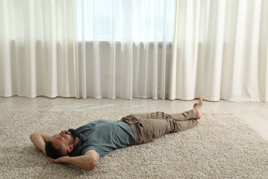 Photo of Harmony. Man lying on rug at home