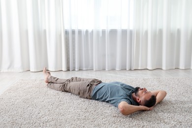 Photo of Harmony. Man lying on rug at home