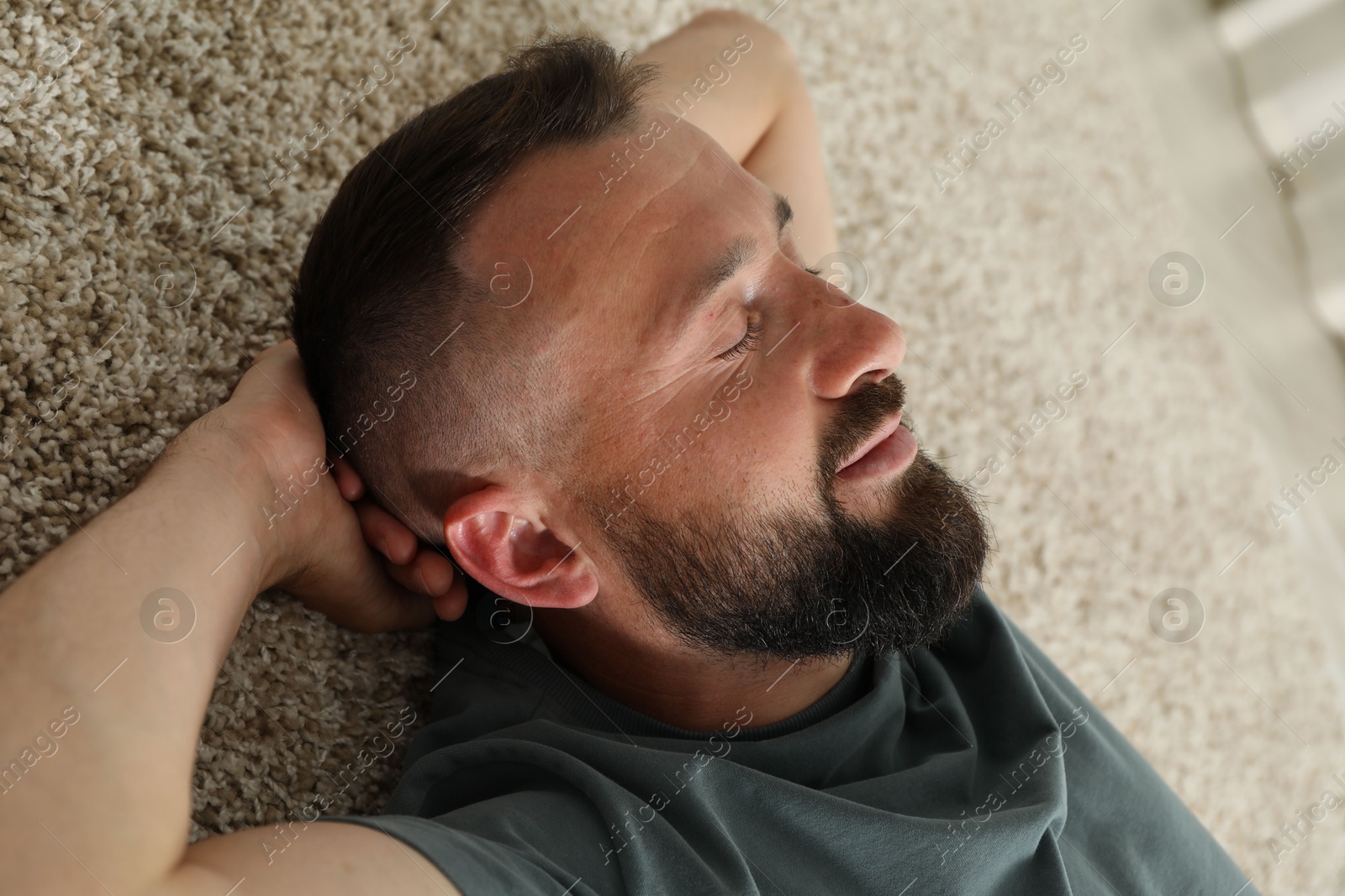 Harmony. Man lying on rug at home, closeup Photo of Harmony. Man lying on rug at home, closeup