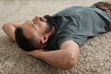 Photo of Harmony. Man lying on rug at home