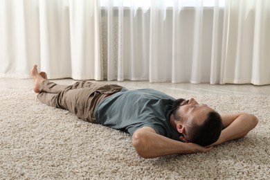 Photo of Harmony. Man lying on rug at home