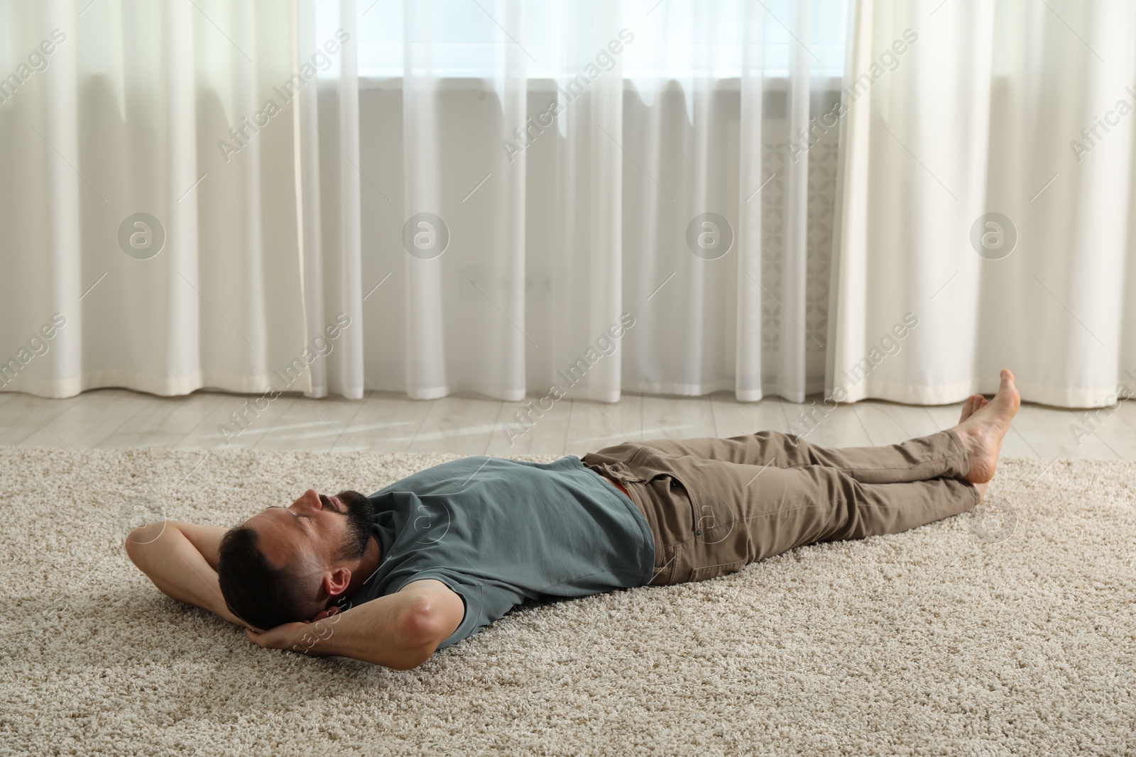 Harmony. Man lying on rug at home Photo of Harmony. Man lying on rug at home