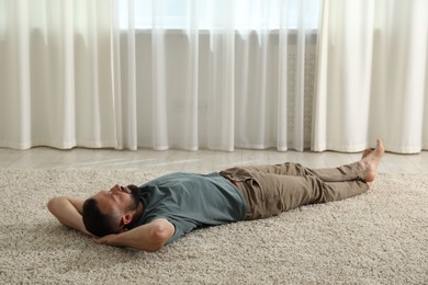 Photo of Harmony. Man lying on rug at home